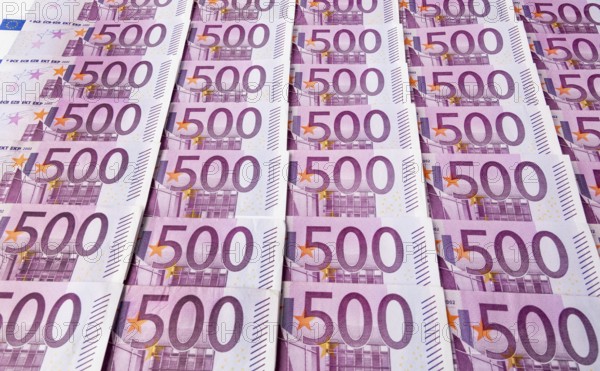 Many five hundred euro banknotes lying next to each other. Symbolic photo for wealth and investment