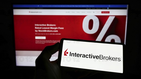 Stuttgart, Germany, 07-24-2022: Person holding mobile phone with logo of American company