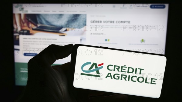 Stuttgart, Germany, 11-16-2023: Person holding smartphone with logo of French financial services