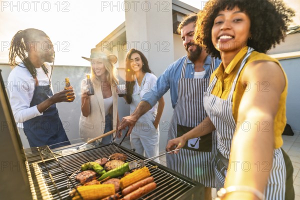 Cheerful multi ethnic friends are having fun, drinking beer and taking selfie while preparing