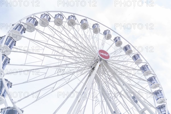 White Ferris wheel with distinctive gondolas in front of a slightly cloudy sky, Ferris wheel