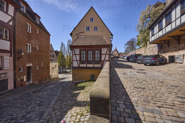 Residential building, historic half-timbered houses, sandstone wall, lantern, cobblestones, trees,