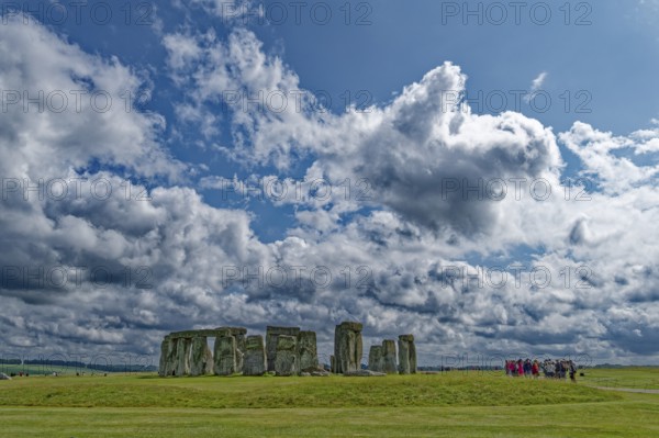A group of tourists visits Stonehenge. The stone circle, a National Trust, UNESCO World Heritage