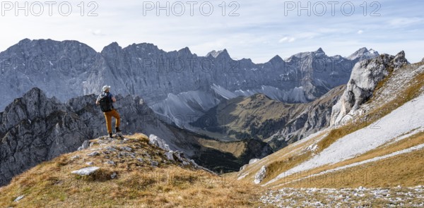 Mountaineers in front of a picturesque mountain landscape in autumn, view of the rocky ridge of the