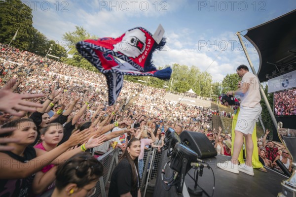 Eisbären Berlin players throw scarves and other fan merchandise into the audience at the Berliner