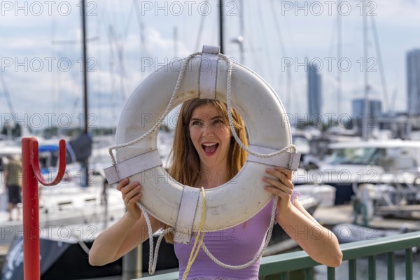 A gorgeous redhead model enjoys the perfect summer weather at a local marina, surrounded by boats