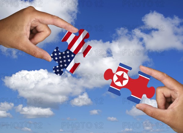 Two hands each holding a puzzle piece, silhouette, confrontation, rapprochement, war, trade war,