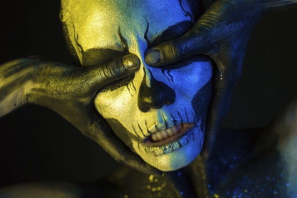 Isolated on black, closeup picture, toned yellow and blue, spooky young blonde caucasian pretty