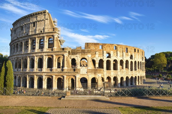 View on the Collosseum from the Forum Romanum on a sunny day and with visitors in the Collosseum