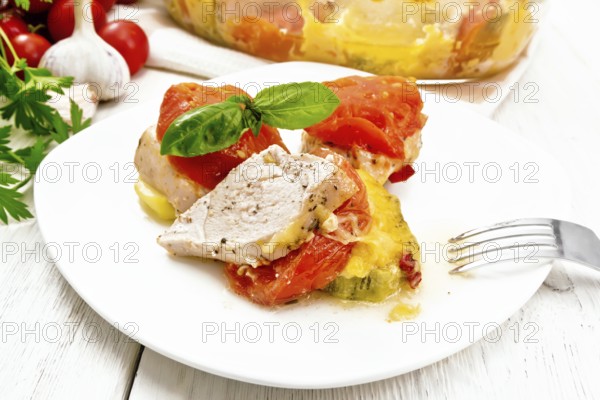 Vegetable casserole with chicken breast, red tomatoes, zucchini and spices in a plate and glass