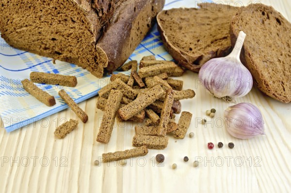Rye homemade bread, crackers, garlic, pepper peas, blue cloth on a background of wooden boards