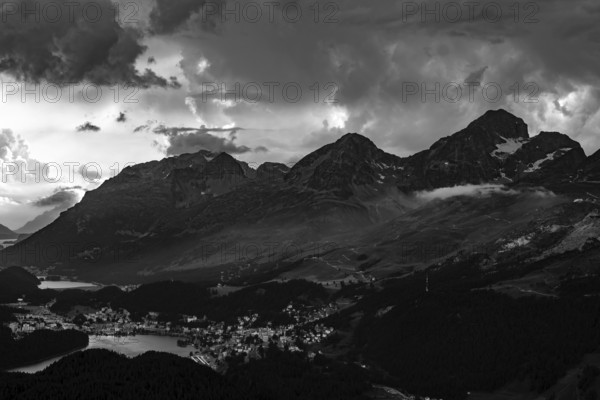 Beautiful Aerial View over Alpine Lakes and Swiss Alps and Cityscape in Sunset and Storm Clouds