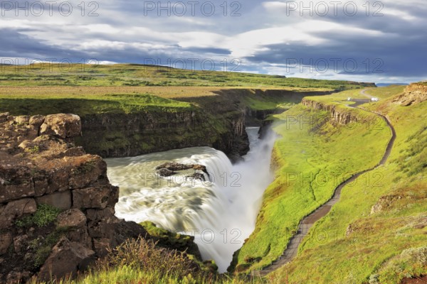 Grand Gullfoss in Iceland. Summer sunny day. Roaring water lit by the morning sun. The river banks
