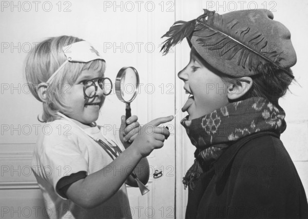 Playing doctor in the 1940s. A little girl is the doctor in this game and looks down her brothers