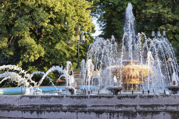 An old fountain with a large bowl in the centre and jets of different shapes in the resort park of