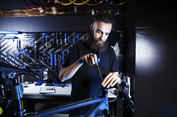 Theme sale and repair of bicycles. Young and stylish with a beard and long hair, a Caucasian man