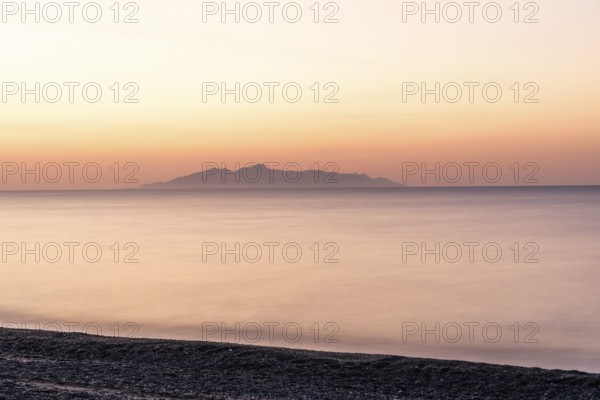 Dawn at sunrise, view from the lava beach near Kamari to the island of Anafi, long exposure, island