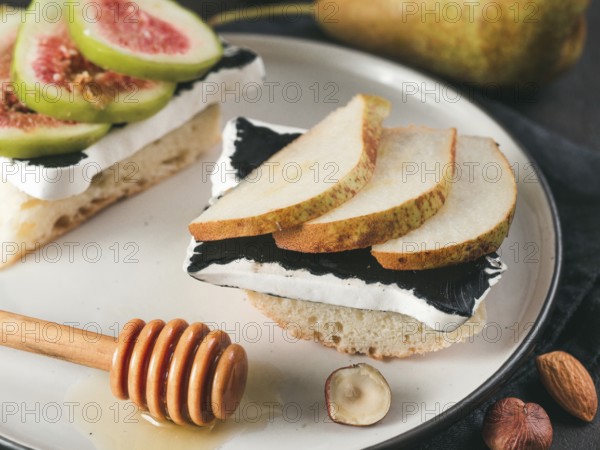 Toast with black camembert cheese and pears slices on plate. Healthy snack or breakfast idea and