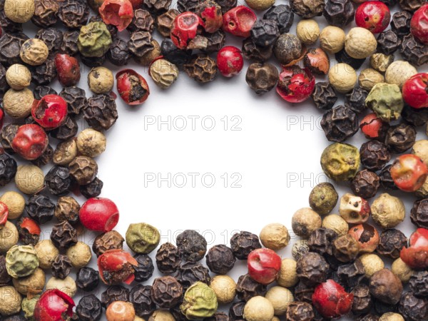 Mixed peppercorns background with white copy space in center. Food background with peppercorns.