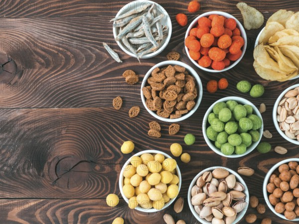 Assortment of different snack for beer, wine, party. Peanuts in coconut glaze, green vasabi, red