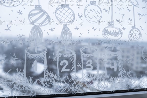 Sustainable responsible holiday decor. Christmas advent candle painted on window glass indoor at