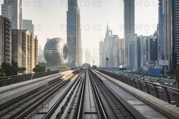 Dubai, UAE - 11.3.2022: Dubai Metro rail with skyscrapers and Museum of the Future in Dubai in the