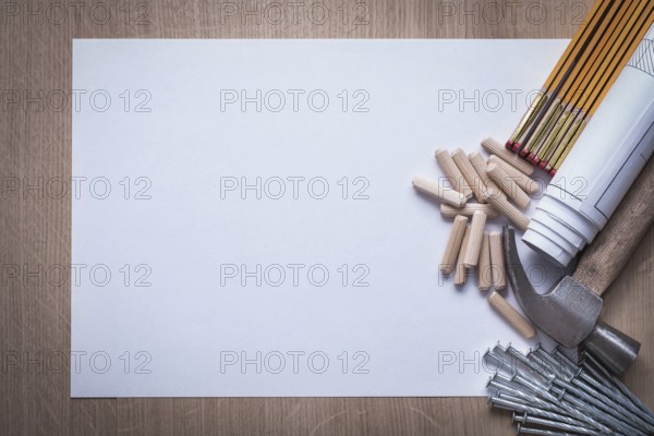 Wooden meter rolled blueprints blank paper nails claw hammer woodworking dowels on wood board copy