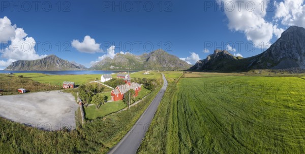 Aerial view of Flakstad church. In the background the peaks of the mountains Hustinden,