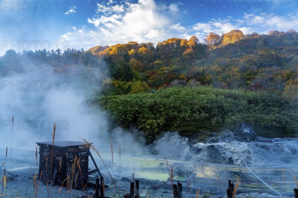 View in Tamagawa onsen in the morning with sunlight shine on the colorful autumn foliage forest on