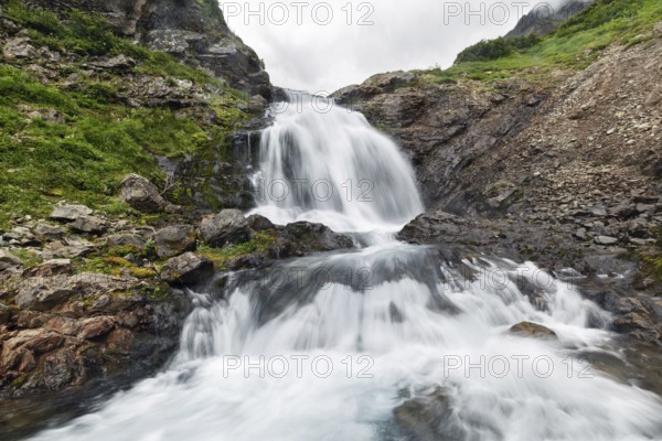 Scenery summer mountain landscape of Kamchatka Peninsula: beautiful view of cascade of flowing