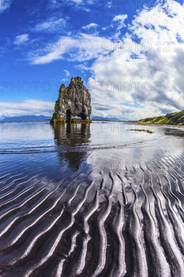 Ocean tide at sunset. The north coast of Iceland. Rock Hvitserkur on the sea beach in the form of a