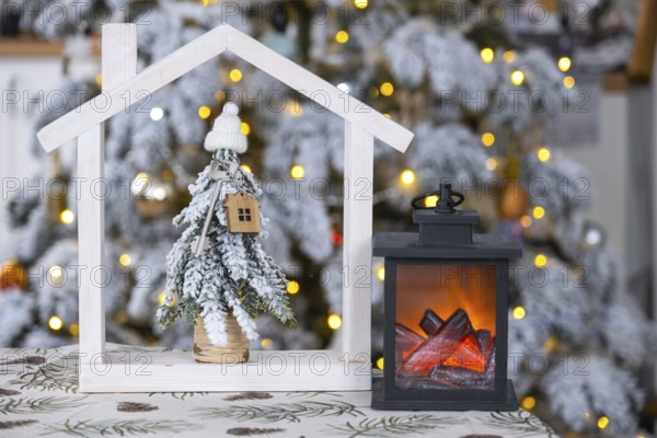 Key on Christmas tree and tiny house on cozy home with Christmas decor on table of festive white