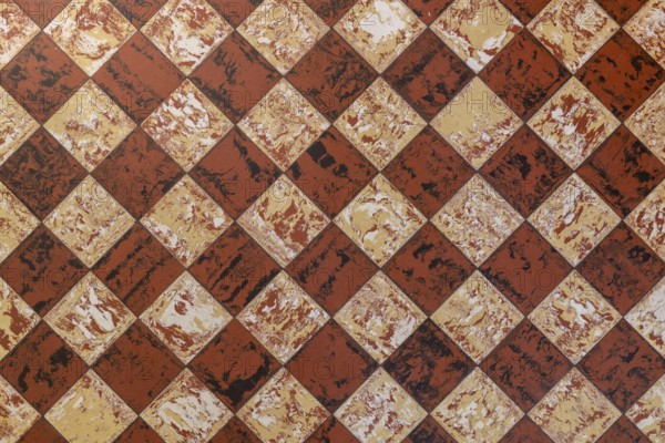 Old-fashioned antique brown beige floor tiles in a characteristic old farmhouse in the Netherlands