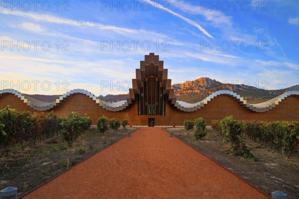 The magnificent modern architecture of Bodegas Ysios. Bright flaming colors of the sunset. Journey