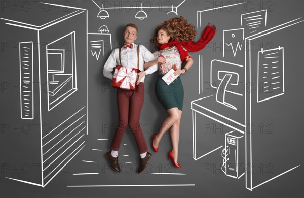 Happy valentines love story concept of an office romance. Young couple at work smiling at each