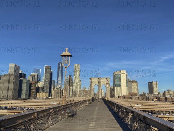 Straight view of the Brooklyn Bridge with skyscrapers and clear sky in the background, New York,