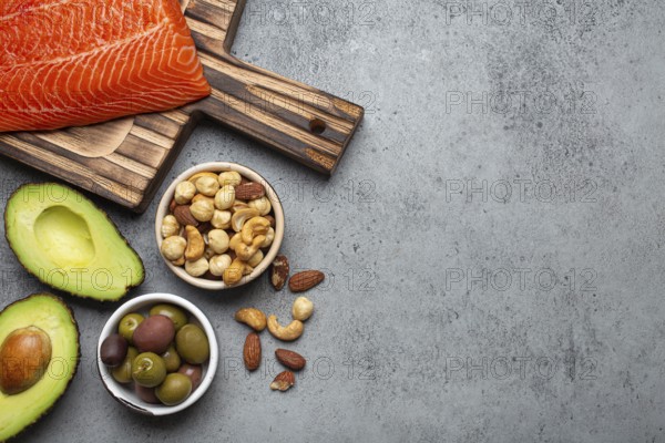 Food sources of healthy unsaturated fat and omega 3: fresh raw salmon fillet, avocado, olives, nuts