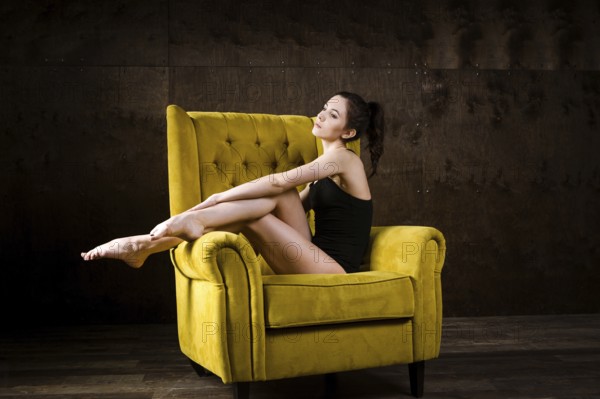A young beautiful, sexy Caucasian woman with thin figure and long bare legs, barefoot posing
