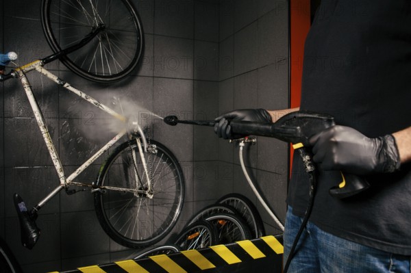 Services professional washing of bicycle in the workshop. Close-up of hand Young Caucasian stylish