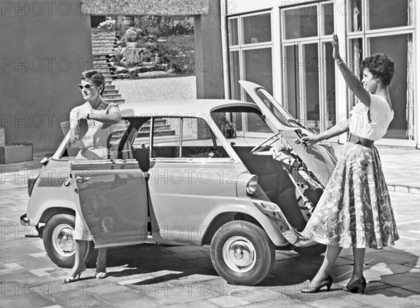 Driving in the 1950s. Two young women is standing beside a car model BMW 600. A micro car model