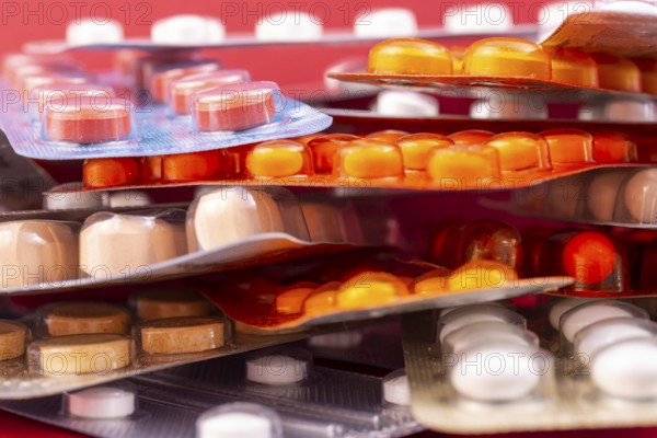 Different colorful capsules and pills in plastic packs - blisters stacked. Global pharmaceutical