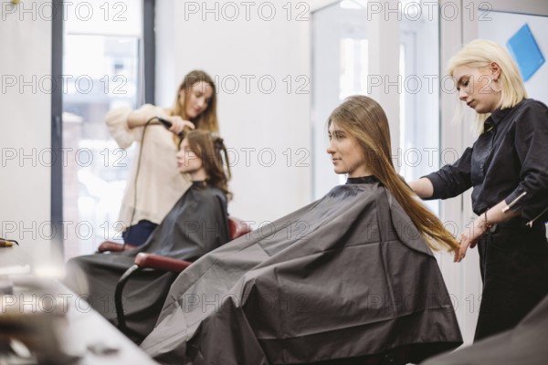 Beautiful woman combing wet hair. stylist brushing woman hair in salon. Hairdresser Serving