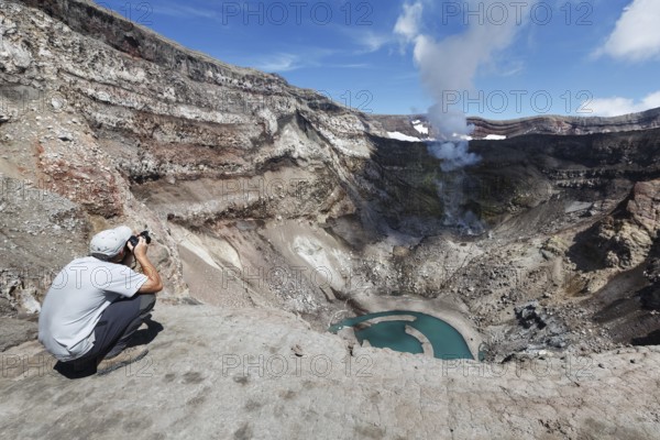 KAMCHATKA, RUSSIA, JULY 21, 2013: Tourist in the crater active Gorely Volcano shoot of the volcano