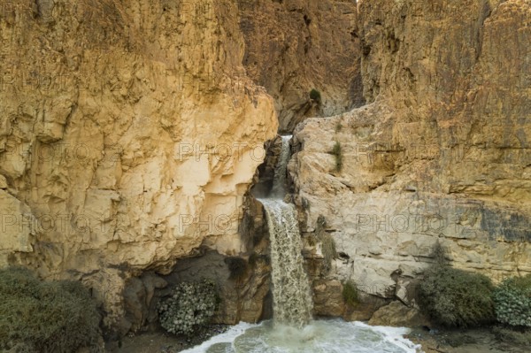 Unexpected powerful waterfall in the Judean Desert around the Dead Sea after heavy winter rains.