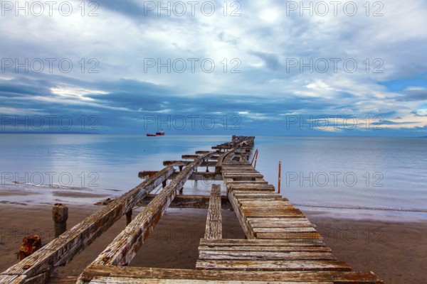South America. Ruined ocean pier in Punta Arenas. The wooden dock flooring collapsed and rotted.
