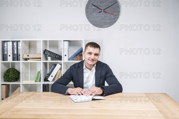 Portrait of a Caucasian male indoors posing in a jacket and white shirt. Overweight office worker