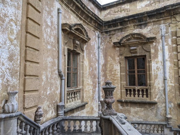 Weathered walls and ornate architectural details with classical windows and stone railing, Villa