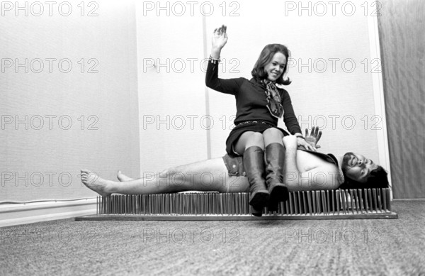 A fakir lies on a mat of nails. The Swedish fakir Mr. Swing, whose real name was Kjell Swing