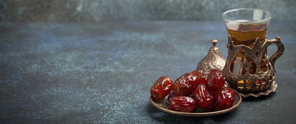 Breaking fasting with dried dates during Ramadan Kareem, Iftar meal with dates and Arab tea in