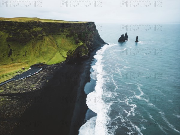 Volcanic Black Sand Beach with a view of Reynisdrangar. Waves crashing on the black sand beach.